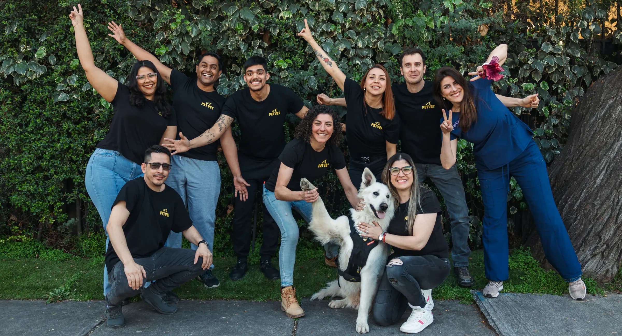 El equipo de Petvet con un perro blanco, al aire libre
